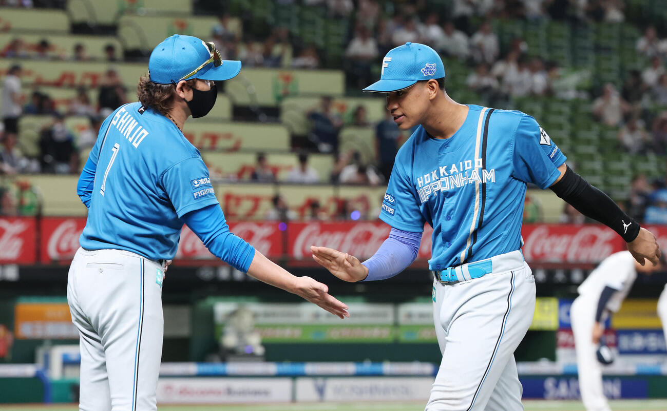 西武対日本ハム　勝利のタッチを交わす日本ハム新庄剛志監督（左）と万波中正（撮影・宮地輝）