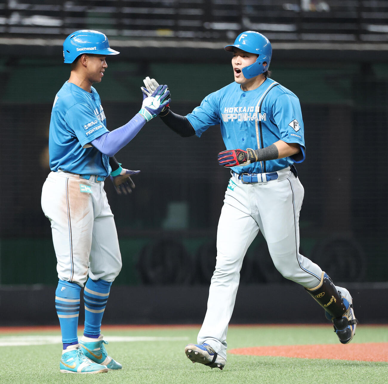 西武対日本ハム　3回表日本ハム2死一、三塁、3点本塁打を放ち万波中正（左）とタッチを交わす野村佑希（撮影・宮地輝）