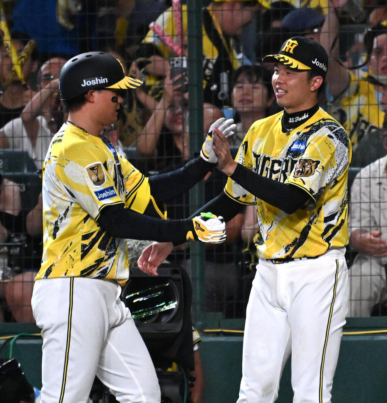 阪神対巨人　9回裏阪神1死満塁、同点犠飛を放った森下翔太（左）と握手をする才木浩人（撮影・石井愛子）