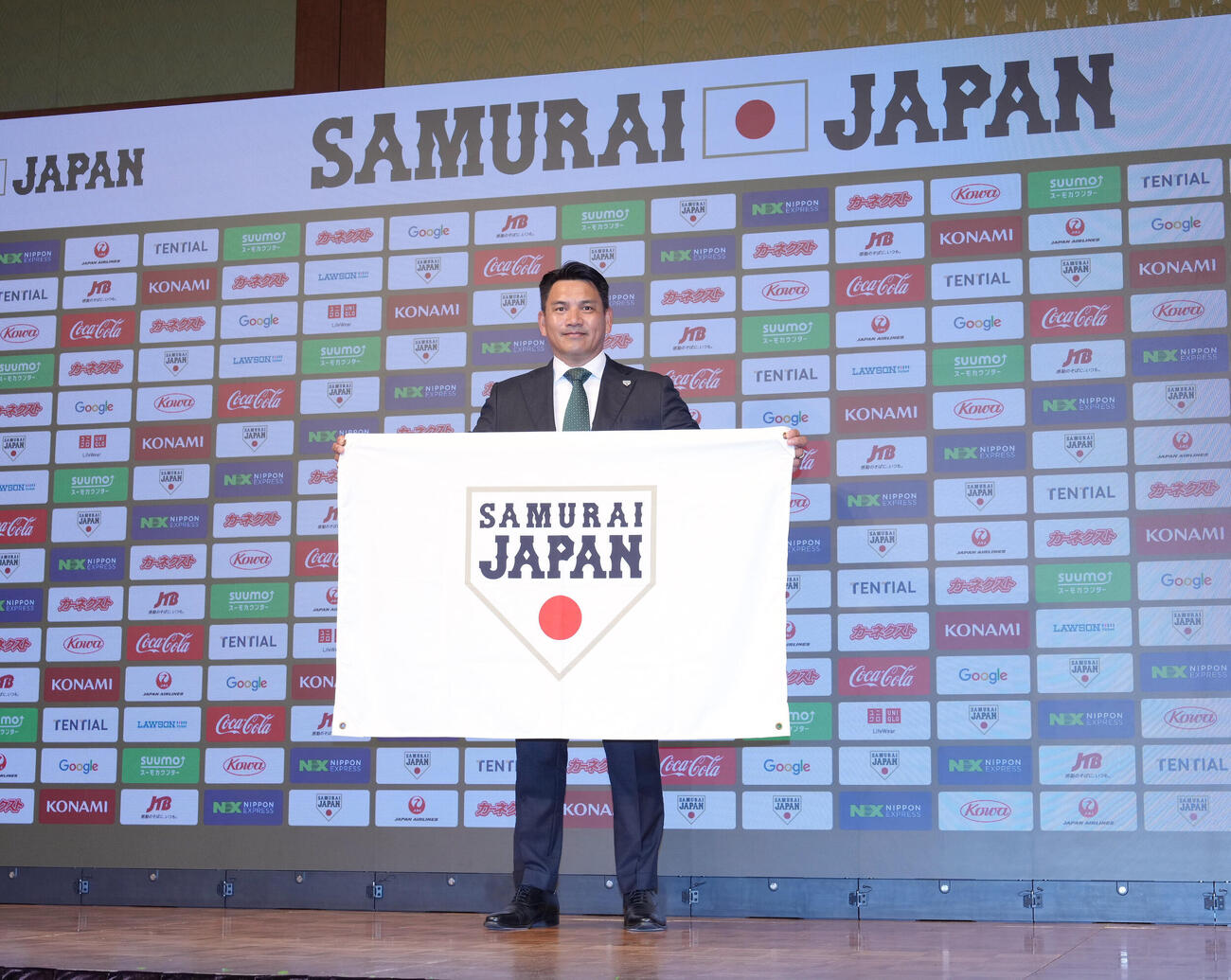 フラッグを手にフォトセッションに臨む侍ジャパン井口資仁監督（撮影・足立雅史）