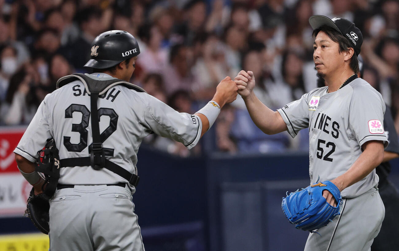 オリックス対ロッテ　8回のピンチをしのいだロッテ2番手益田直也は佐藤都志也とタッチをかわす（撮影・西尾就之）