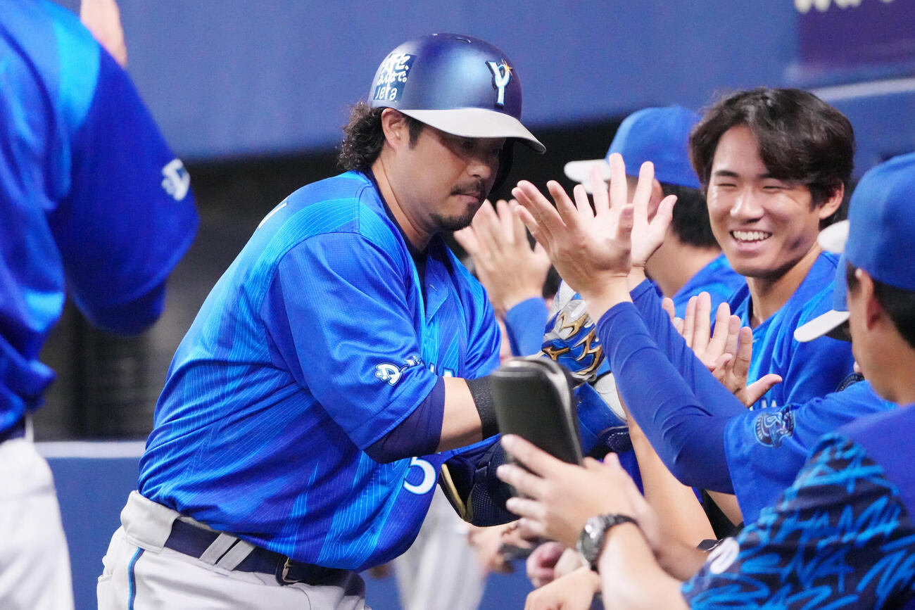 中日対DeNA 4回表DeNA2死、宮崎敏郎（左）は本塁打を放ちナインとタッチを交わす（撮影・森本幸一）