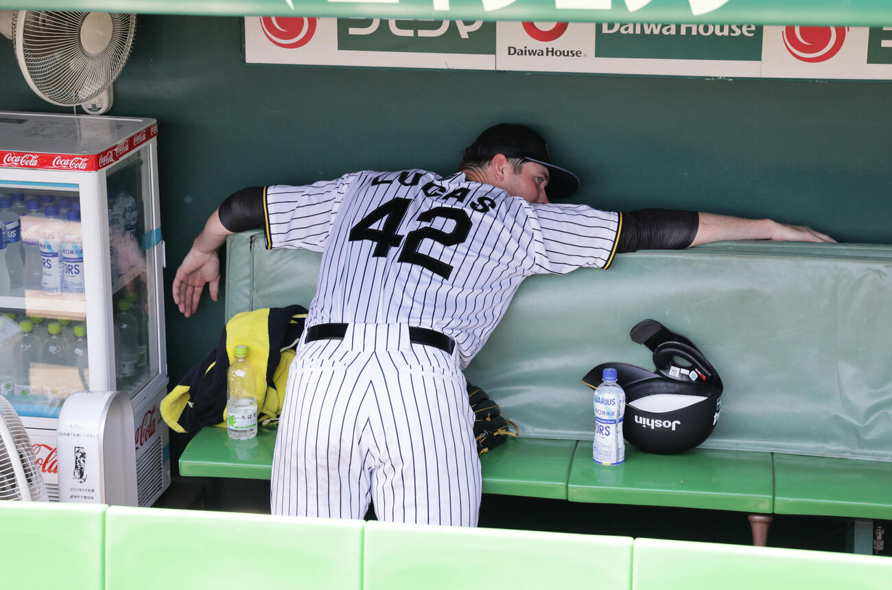 練習前の甲子園でライブBP登板した阪神イーストン・ルーカスは、「暑い～」とベンチ後方から吹き出る冷風で体を冷やす（撮影・宮崎幸一）