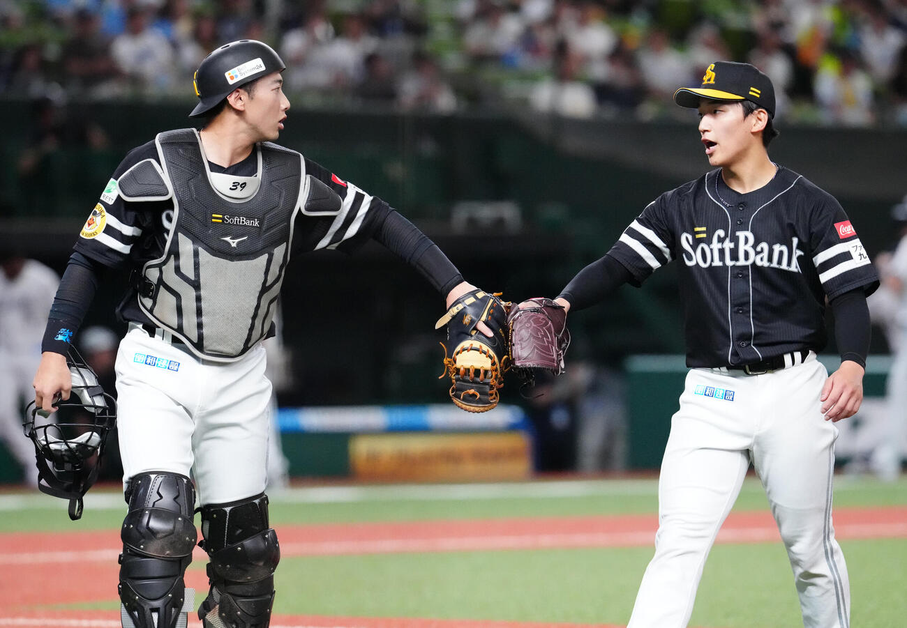 西武対ソフトバンク　2回裏終了後、ソフトバンク捕手山本祐大（左）とタッチを交わす先発の前田悠伍（撮影・江口和貴）