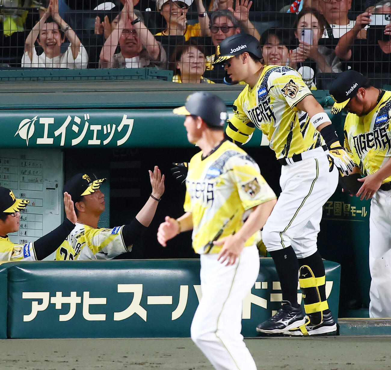 阪神対巨人　6回裏阪神無死、佐藤輝明は中越えソロ本塁打を放ちベンチの藤川球児監督（左）とタッチする（撮影・加藤哉）
