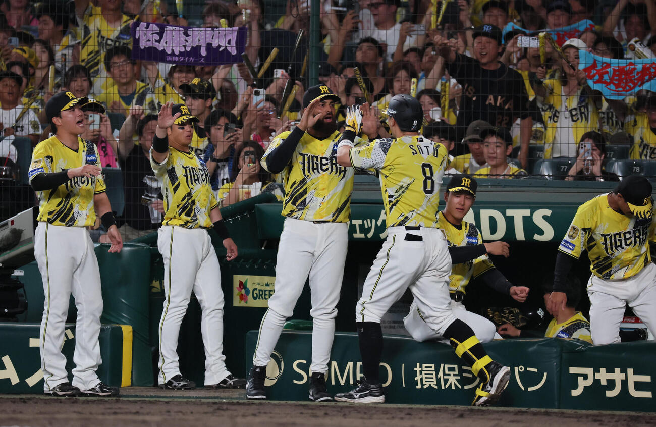 阪神対巨人　6回裏阪神無死、バックスクリーンに先制本塁打を放った佐藤輝明を迎える阪神ナイン（撮影・宮崎幸一）