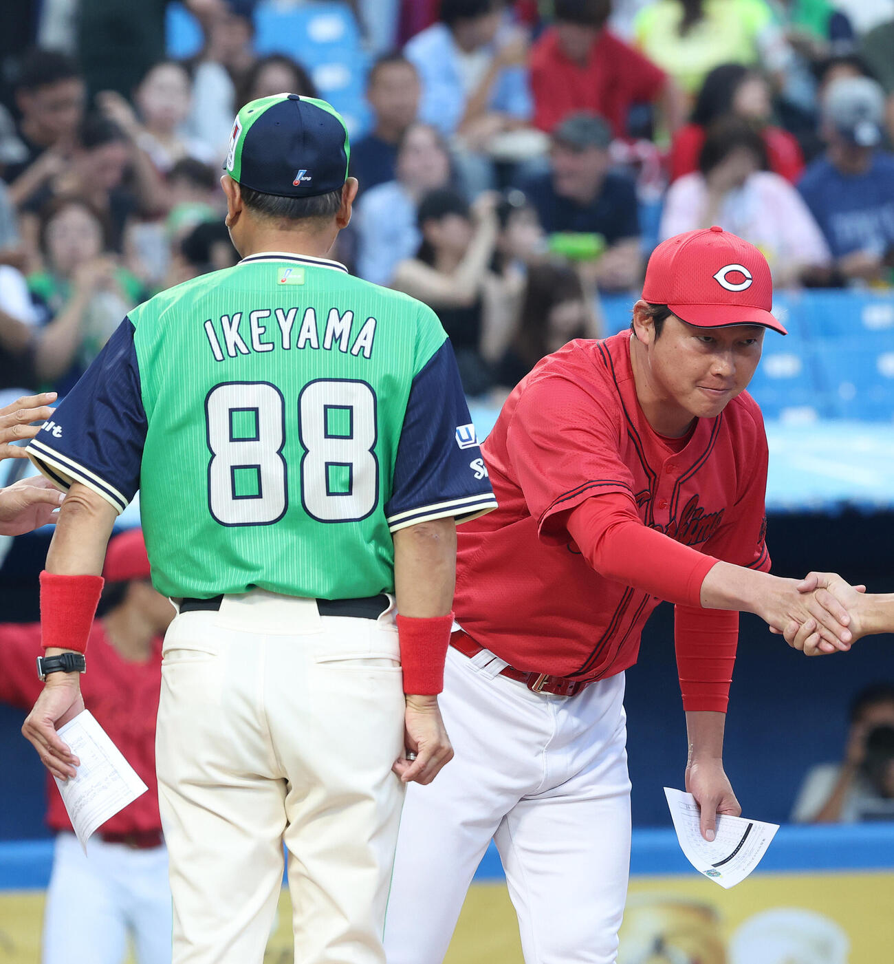 ヤクルト対広島　開始前、ヤクルト池山隆寛監督（左）とメンバー表交換する広島新井貴浩監督（撮影・河田真司）