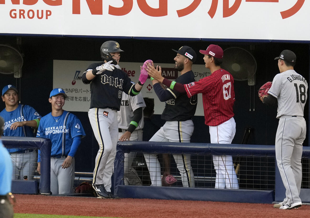 1回表パ選抜2死二塁、ケインの先制適時二塁打で生還しナインから祝福される麦谷祐介（手前）