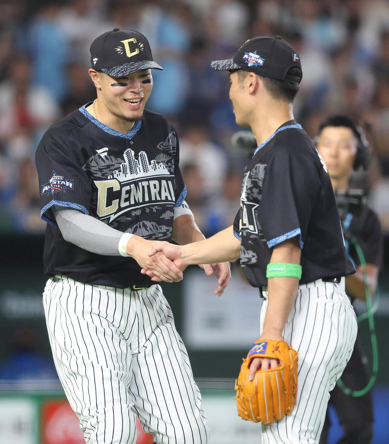 全セ対全パ　試合前、ホームランダービーを終え、打撃投手を務めた坂本誠志郎（右）と握手を交わす阪神佐藤輝明