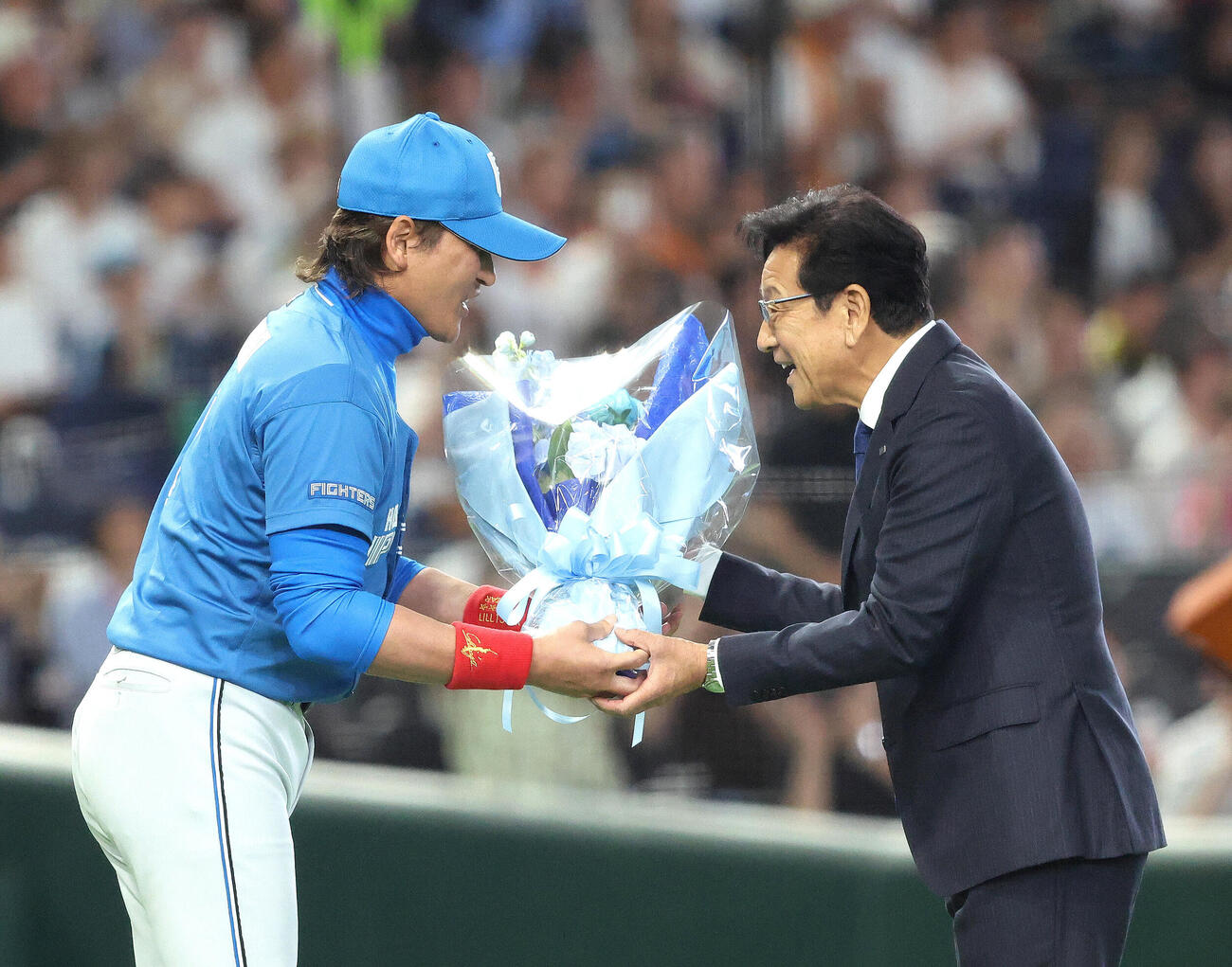 全セ対全パ　試合前、野球殿堂入り表彰で日本ハム新庄剛志監督（左）から花束を受け取る栗山英樹氏（撮影・河田真司）