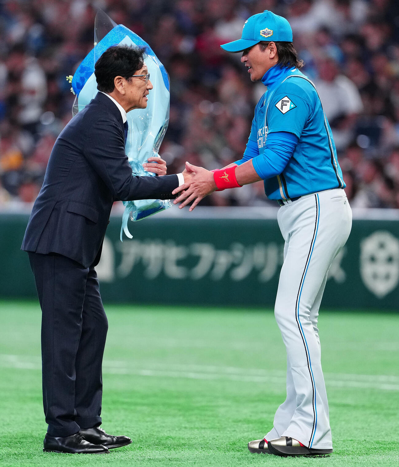全セ対全パ　野球殿堂入りの表彰式で日本ハム新庄剛志監督（右）から花束を受け取る栗山英樹氏（撮影・鈴木みどり）