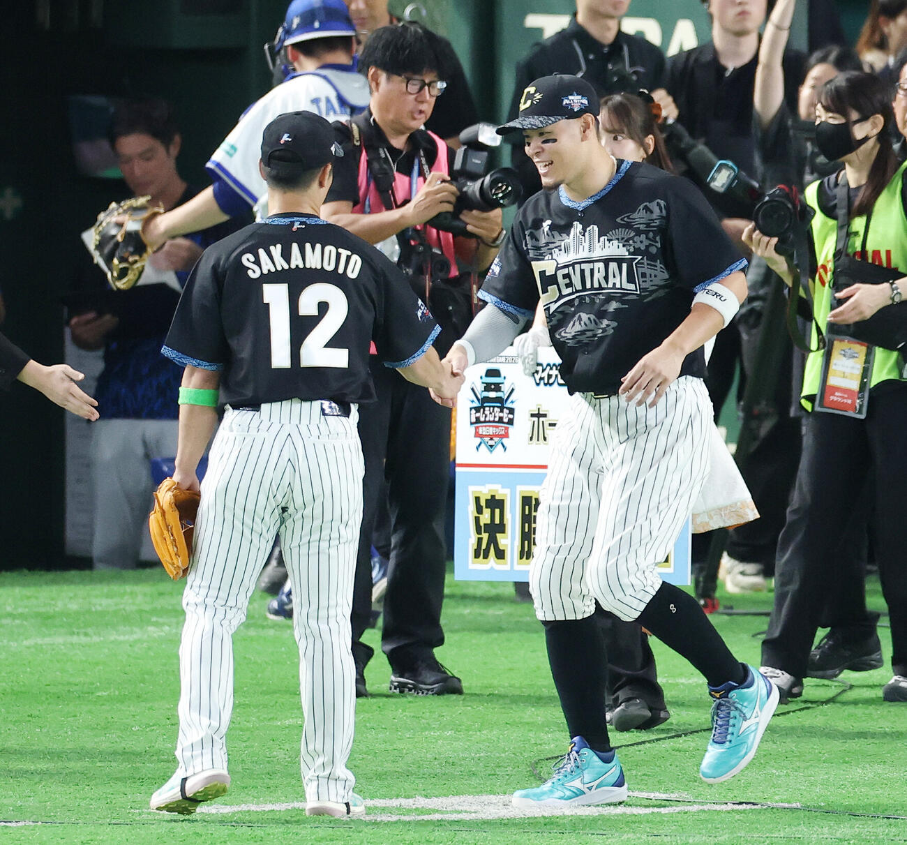 全セ対全パ　ホームランダービーで決勝進出を決め投手を務めた阪神坂本誠志郎（左）と握手する佐藤輝明（撮影・宮地輝）