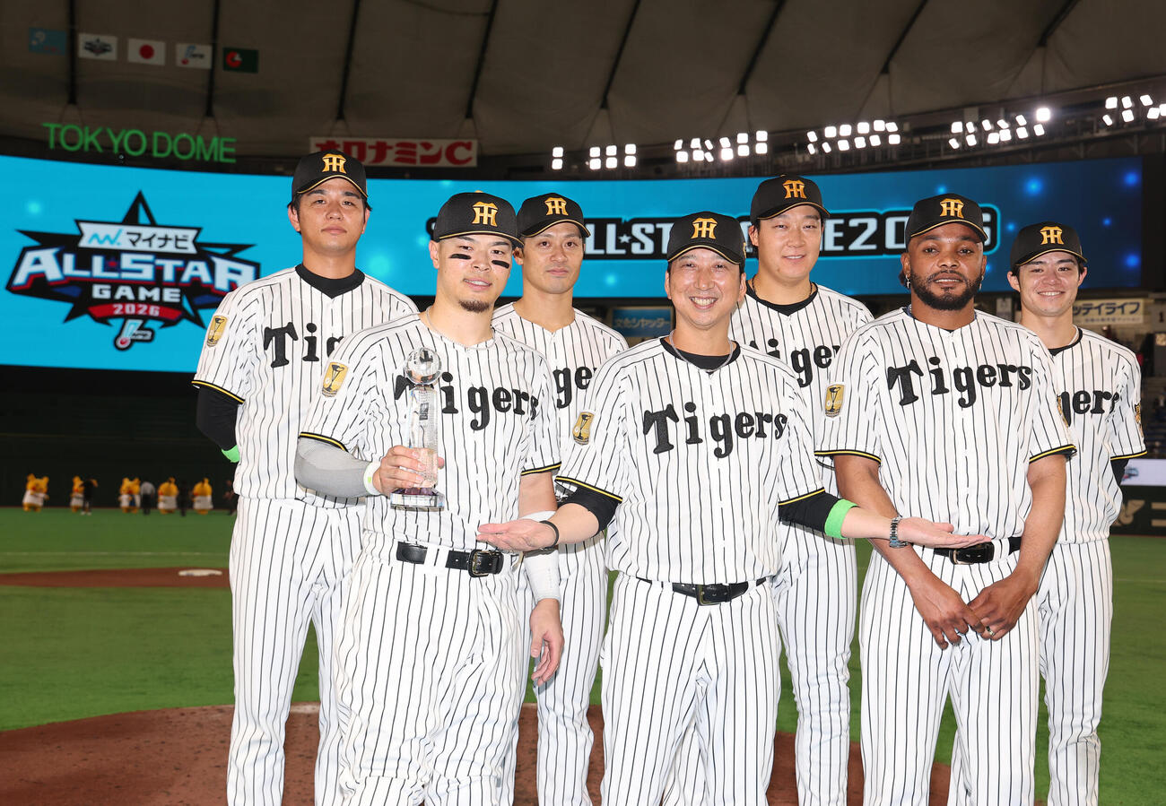全セ対全パ　試合後、藤川球児監督（中央）を囲み写真に納まる阪神の、左から高橋遥人、佐藤輝明、坂本誠志郎、1人おいて大山悠輔、ドリス、中野拓夢（撮影・河田真司）