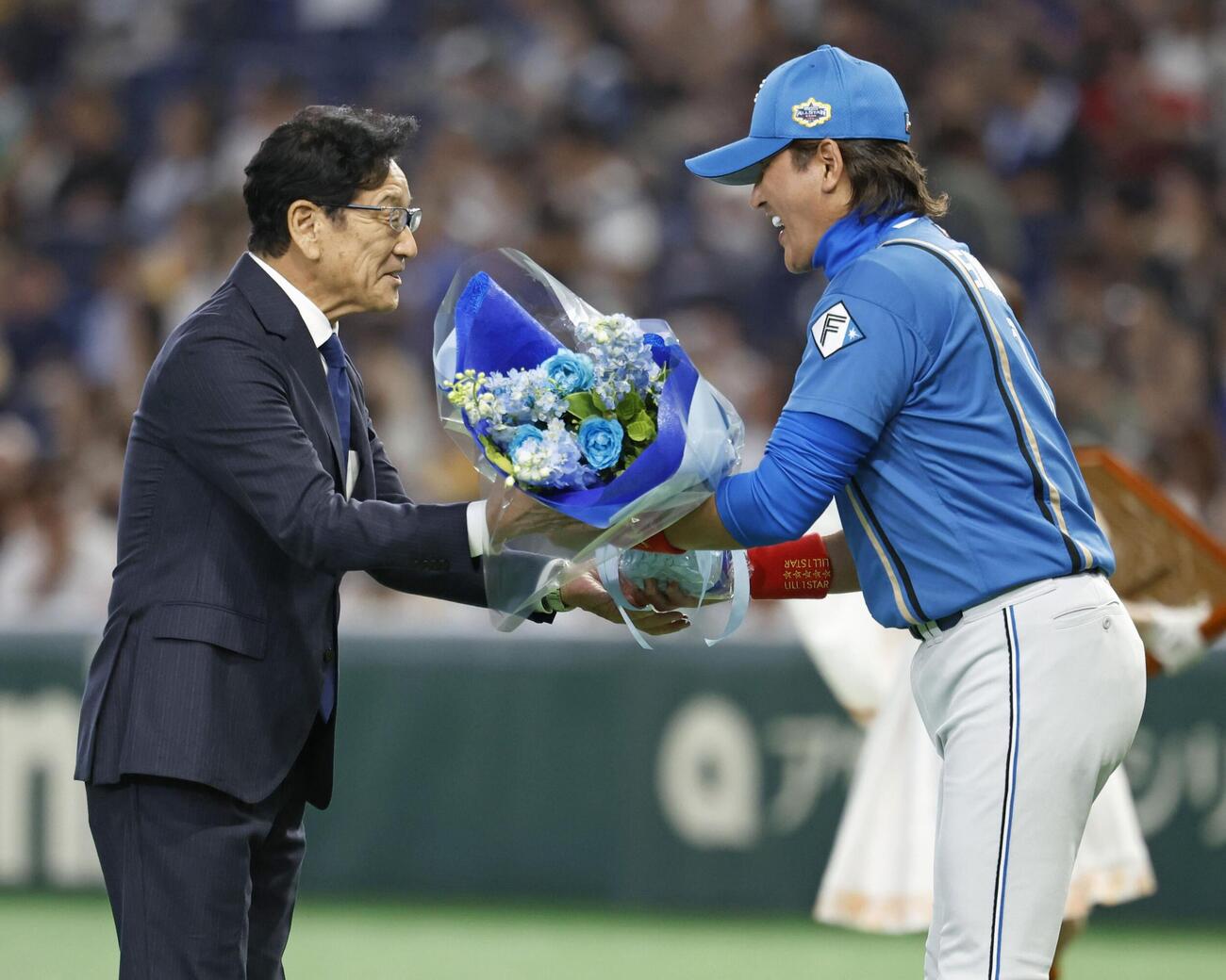 野球殿堂入り表彰式で、日本ハム・新庄監督（右）から花束を受け取る栗山英樹さん＝28日、東京ドーム