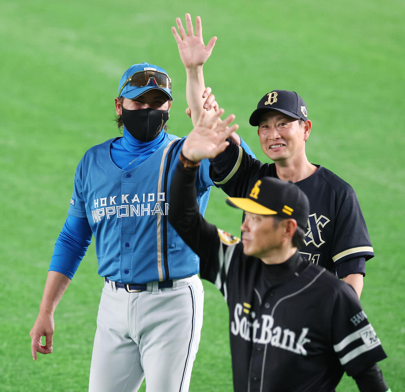 全セ対全パ　試合後、オリックス岸田護監督（右）の腕を掴みファンに手を振る日本ハム新庄剛志監督（撮影・宮地輝）
