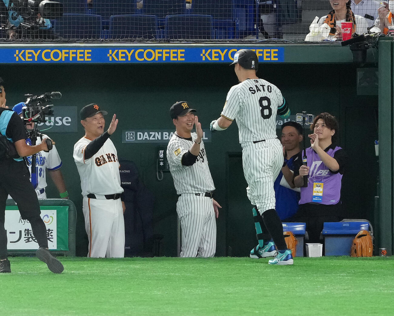 マイナビオールスターゲーム2026　第1戦　1回表全セ1死、佐藤輝明（右）は先制本塁打を放ち藤川球児監督（中央）とタッチを交わす（撮影・足立雅史）