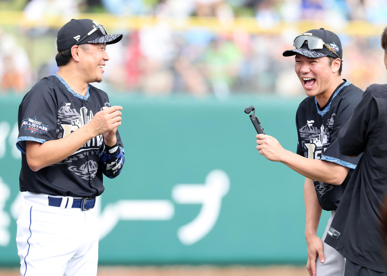 全パ対全セ　試合前、カメラを手に中日大野雄大（左）に取材し大笑いする巨人坂本勇人（撮影・浅見桂子）