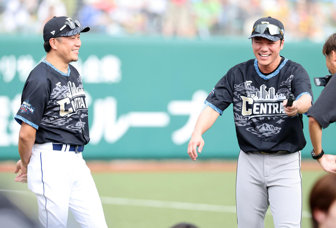 全パ対全セ　試合前、カメラを手に中日大野雄大（左）に取材し大笑いする巨人坂本勇人（撮影・浅見桂子）