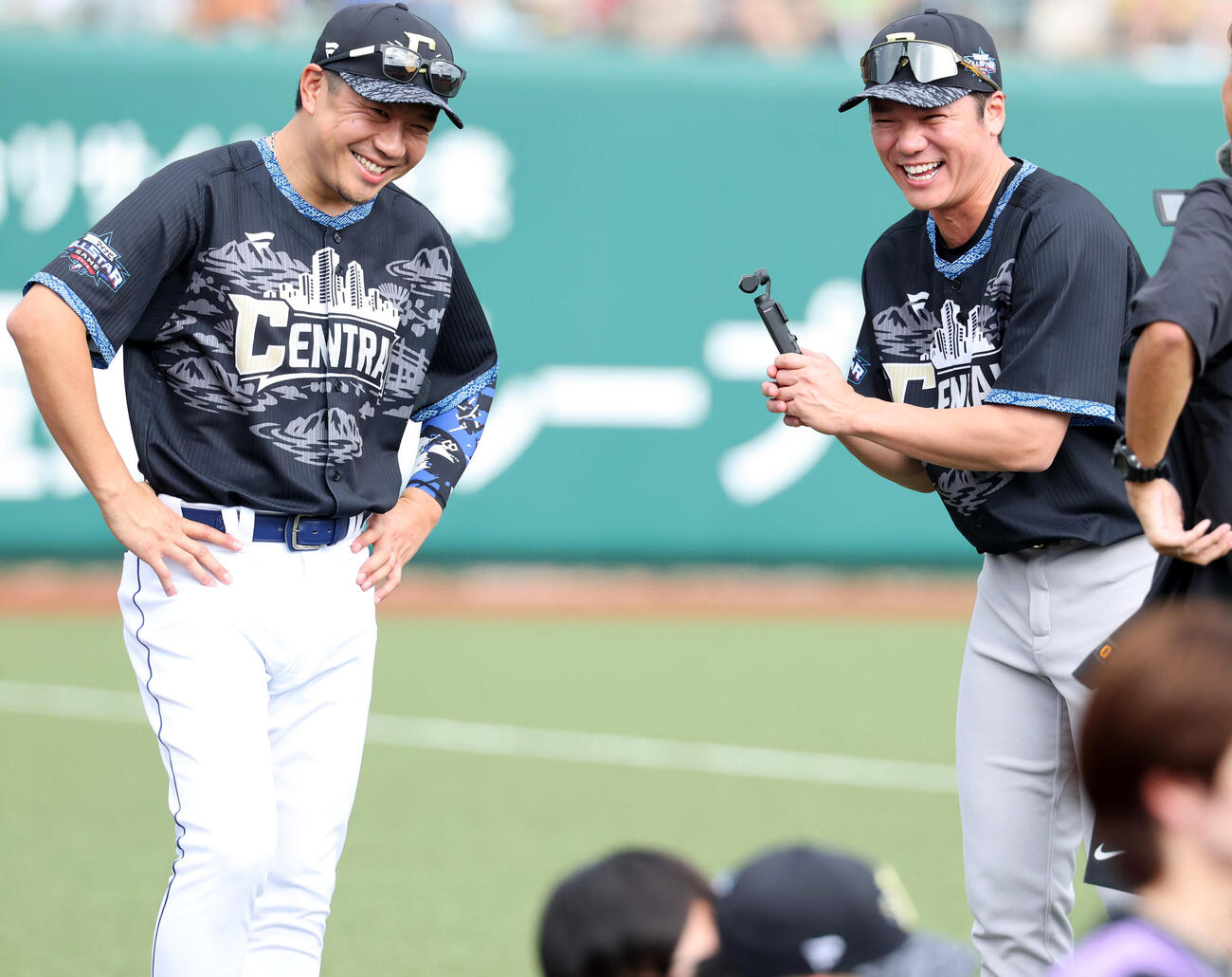 全パ対全セ　試合前、カメラを手に中日大野雄大（左）に取材し大笑いする巨人坂本勇人（撮影・浅見桂子）