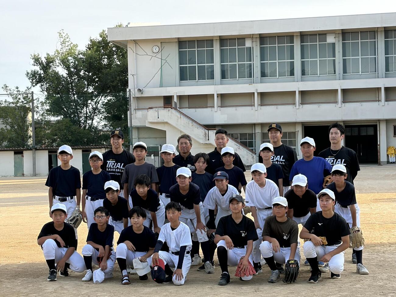 阪神が「大社軟式野球クラブ」の初回練習で記念撮影するコーチ陣と選手たち（撮影・磯綾乃）