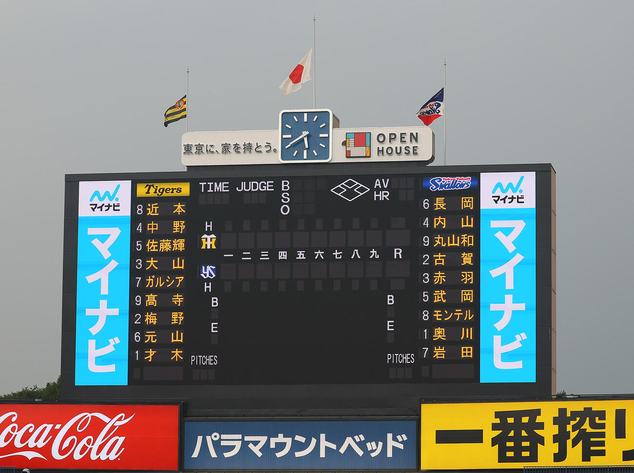 ヤクルト対阪神　発表された両軍先発メンバー。スコアボード上には半旗が掲げられた（撮影・水谷安孝）