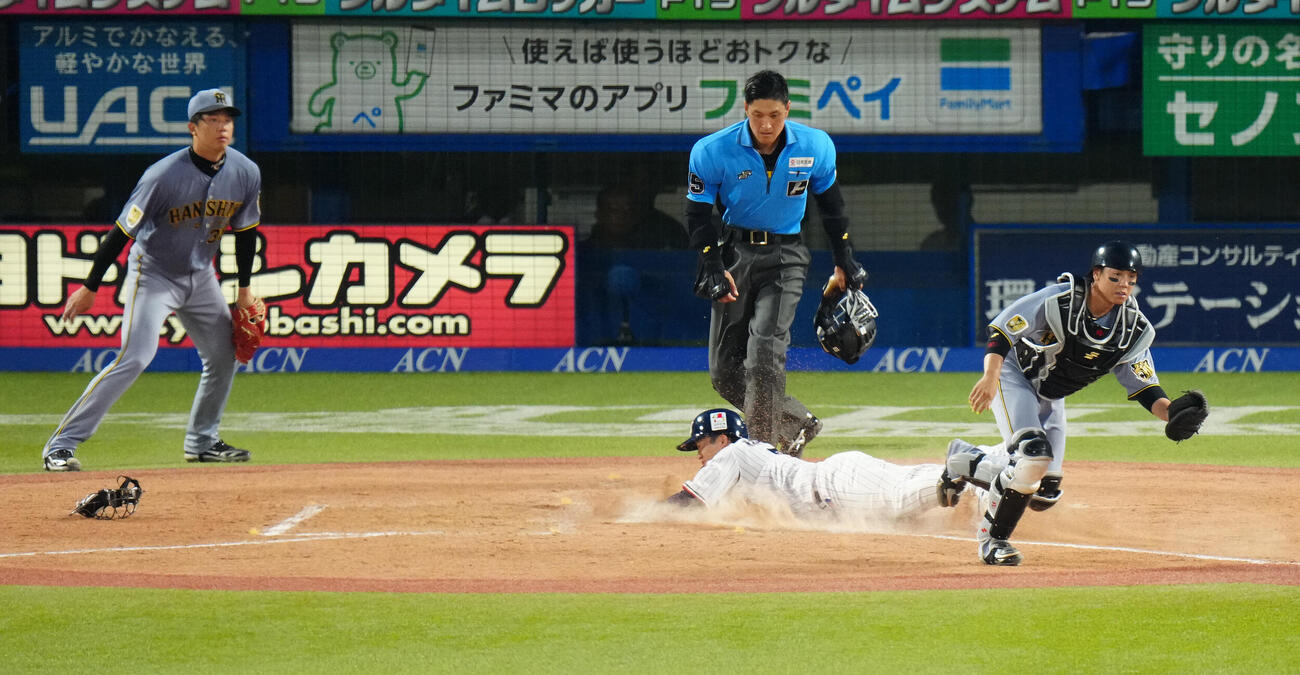 ヤクルト対阪神　2回裏ヤクル2死一、二塁、丸山和郁の適時打で生還する二塁走者長岡秀樹。捕手梅野隆太郎（撮影・鈴木みどり）