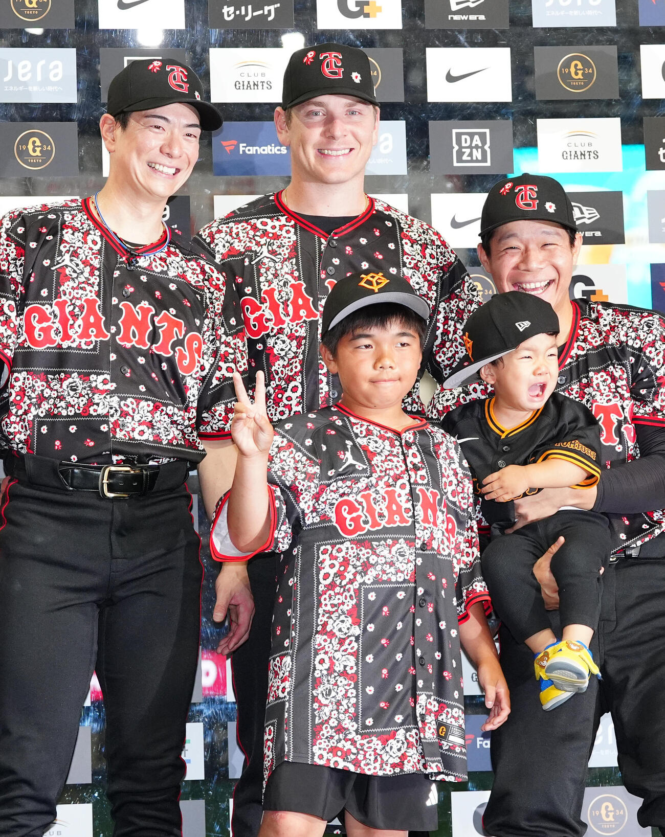 巨人対DeNA　試合後、ファンとの記念撮影で男の子を抱っこするも泣かれる巨人佐々木俊輔（右端）。左から松本剛、スペンサー・ハワード（撮影・江口和貴）