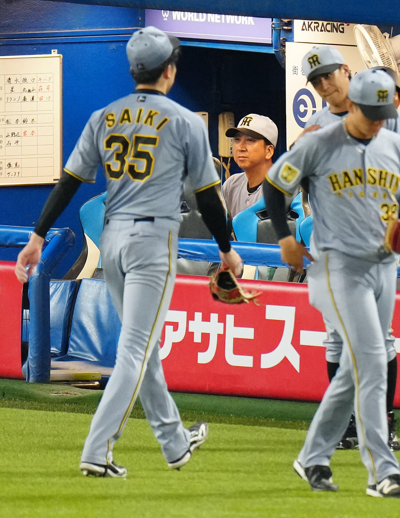 ヤクルト対阪神　6回裏、降板する阪神才木浩人（左）とベンチで浮かない表情の藤川球児監督（後方）（撮影・鈴木みどり）