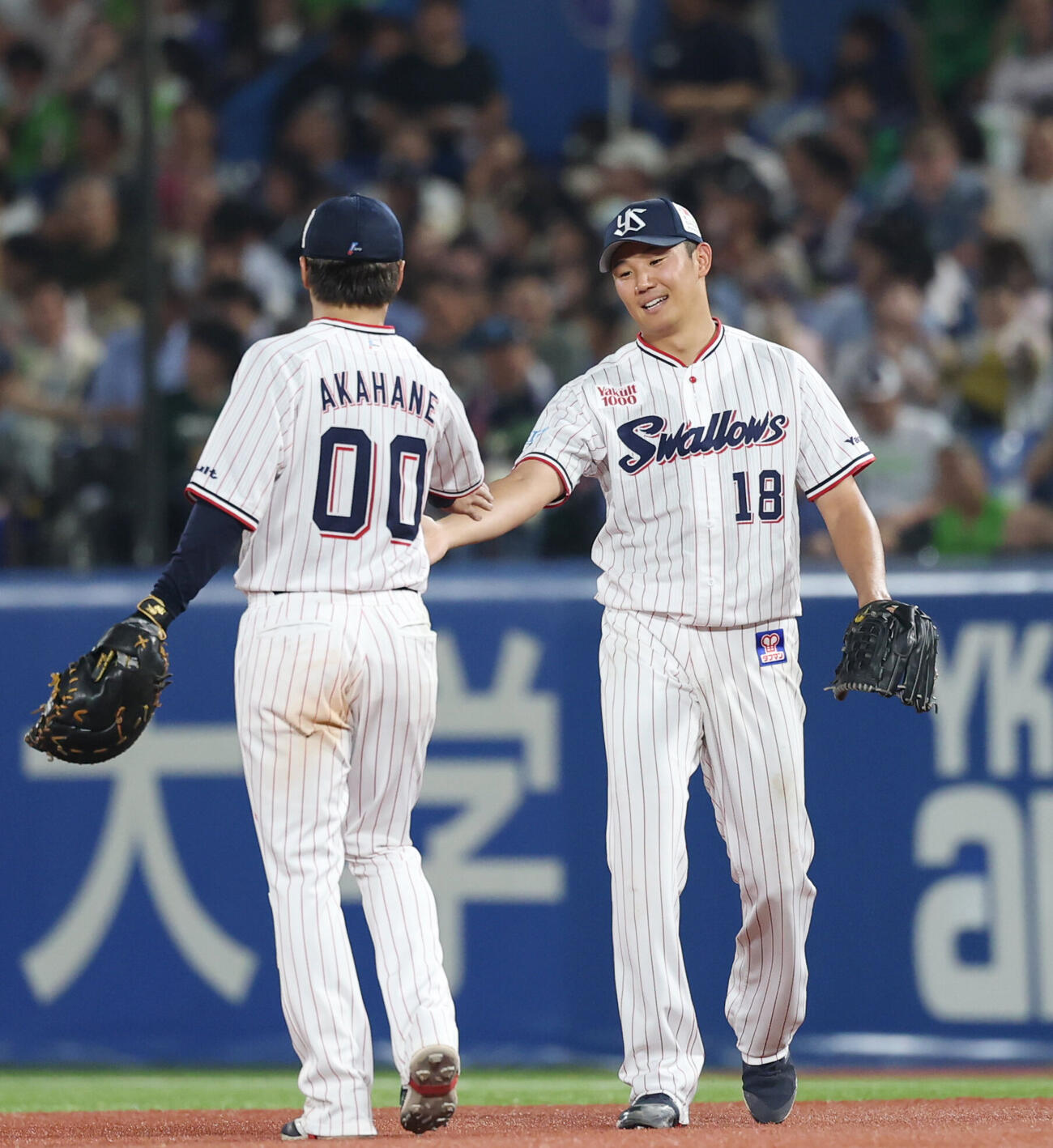 ヤクルト対阪神　5回裏阪神無死、近本光司の打球を1ゴロに仕留めた赤羽由紘（左）とタッチを交わす奥川恭伸（撮影・増田悦実）