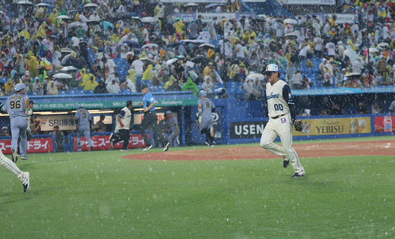 ヤクルト対阪神　1回表阪神2死一、二塁、突然の豪雨でベンチに引き揚げる両軍ナイン（撮影・水谷安孝）