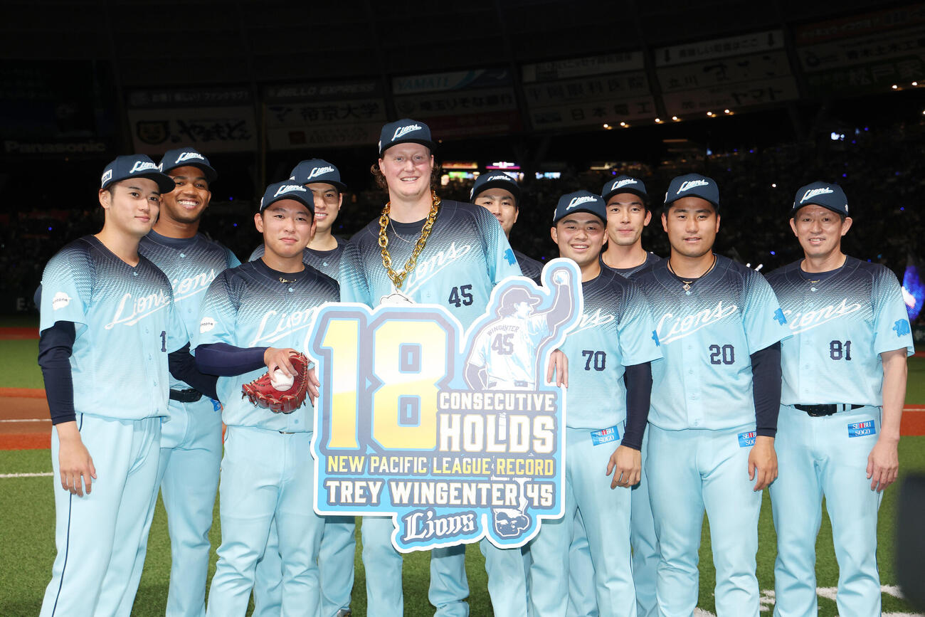 西武対オリックス　パ・リーグ新記録となる連続18ホールドを達成し、チームメートから祝福を受ける西武トレイ・ウィンゲンター（中央）（撮影・河田真司）