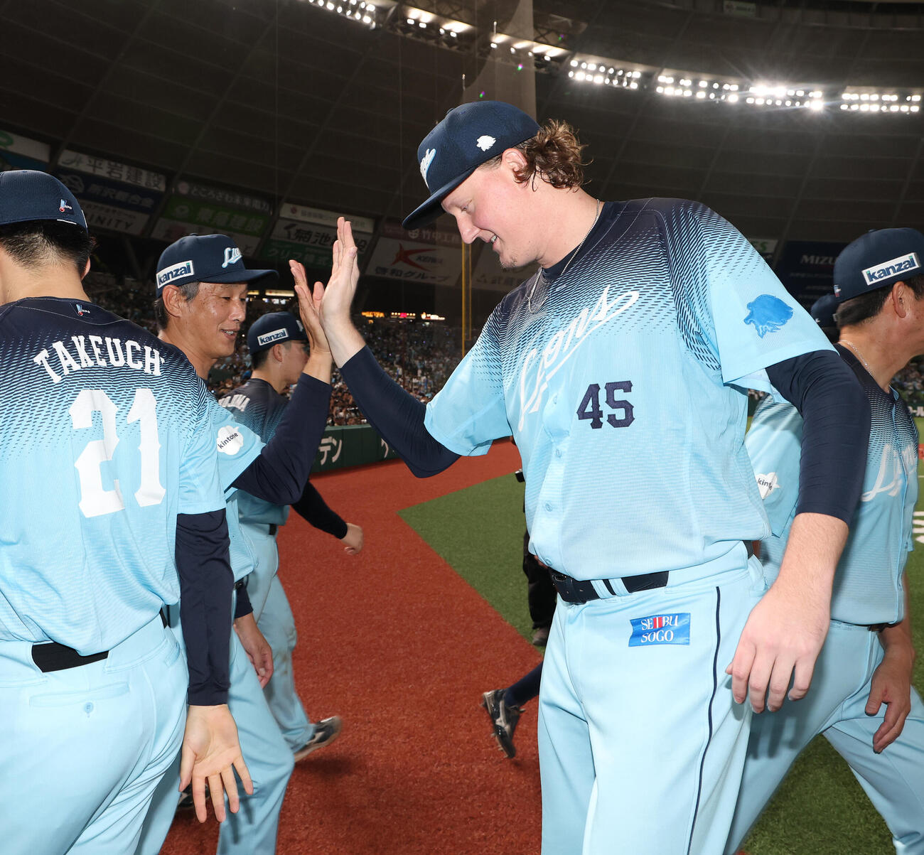 西武対オリックス　パ・リーグ新記録となる連続18ホールドを達成し、西口文也監督（左）とタッチを交わす西武トレイ・ウィンゲンター（撮影・河田真司）