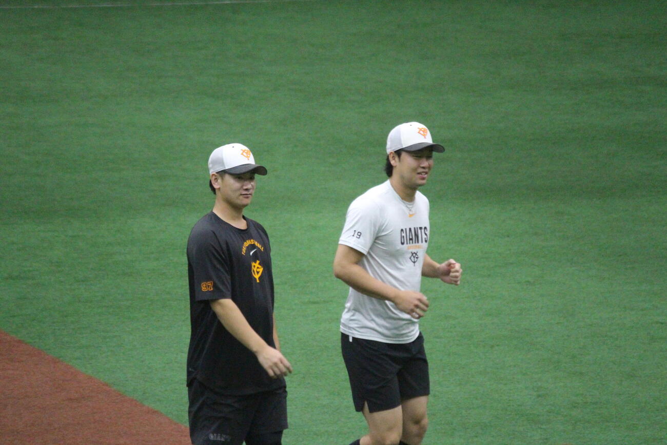 練習中に笑顔の山崎伊織と井上温大
