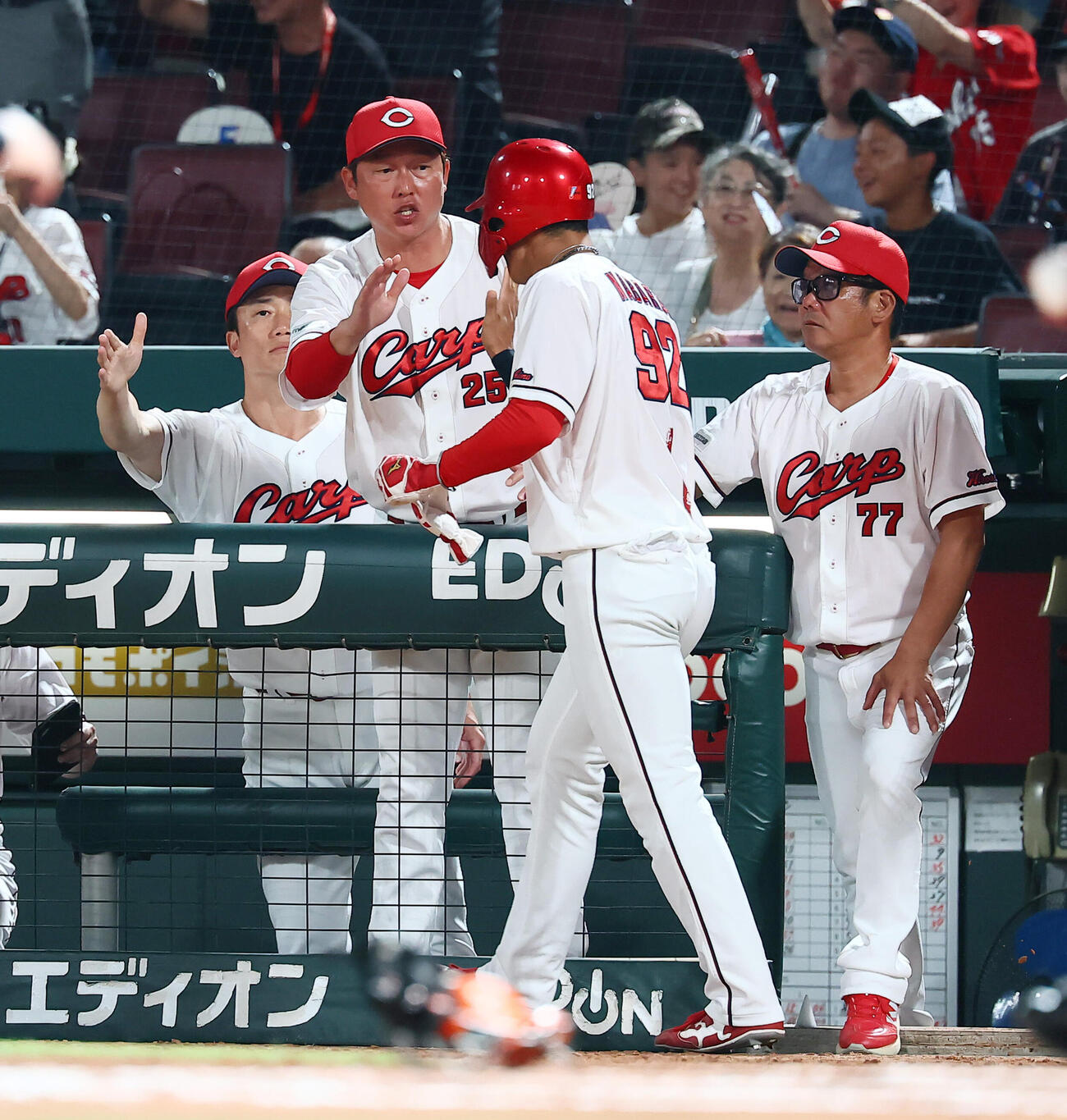 広島対巨人　8回裏広島無死三塁、新井貴浩監督は小園海斗の適時内野安打で生還した三走代走名原典彦（右）とタッチする（撮影・加藤哉）
