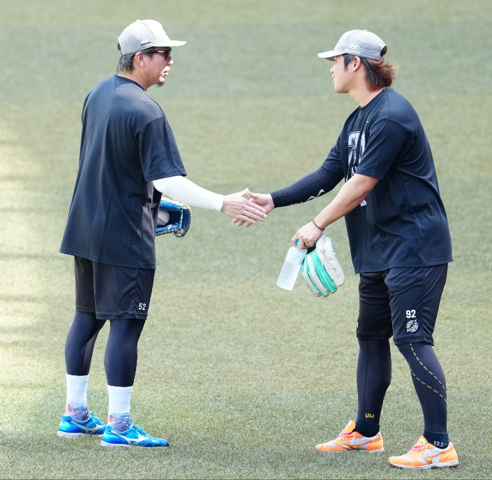ロッテ対西武　試合前練習で益田直也（左）と握手を交わすロッテ森遼大朗（撮影・鈴木みどり）