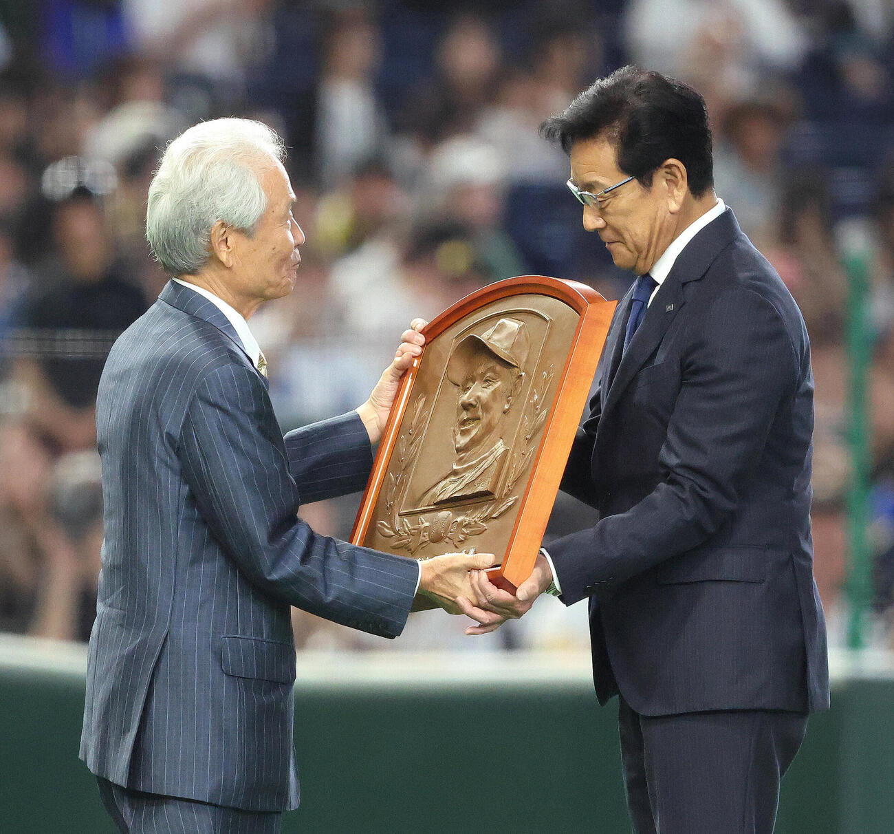 7月28日、オールスターの試合前、野球殿堂入り表彰で榊原定征コミッショナー（左）から盾を受け取る栗山英樹氏