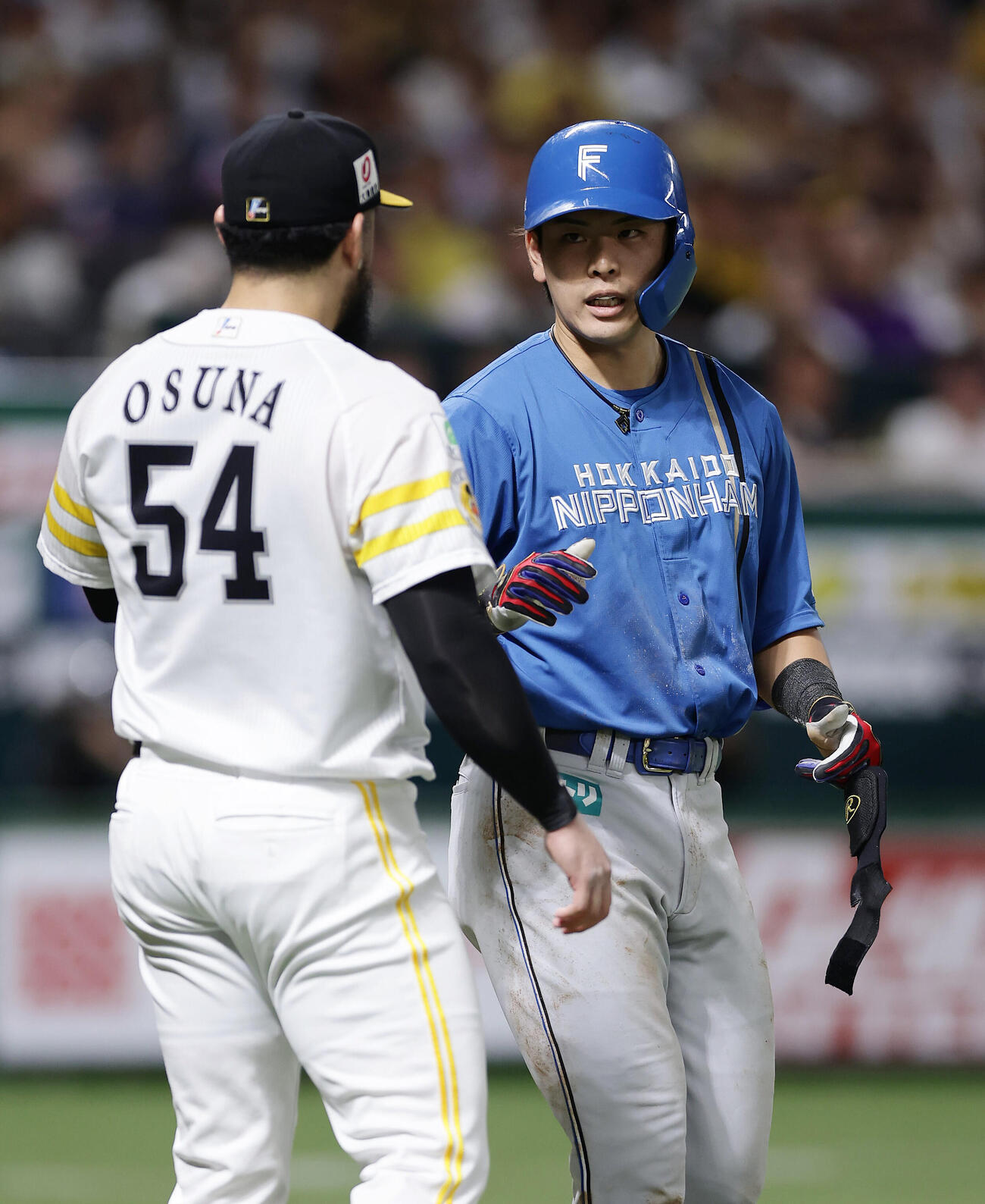 ソフトバンク対日本ハム　8回表日本ハム1死満塁、頭部に死球を受け、ロベルト・オスナ（左）に謝罪されながら一塁へ向かう野村佑希（撮影・前田充）