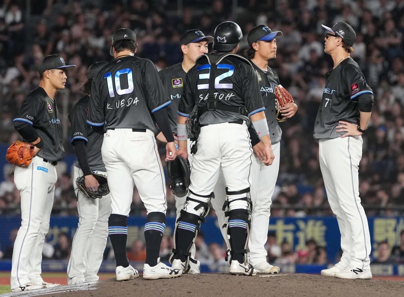 ロッテ対オリックス　8回表オリックス無死一、二塁、2者連続死球を与えたロッテ2番手坂本光士郎（右から2人目）はナインの激励を受ける（撮影・小沢裕）