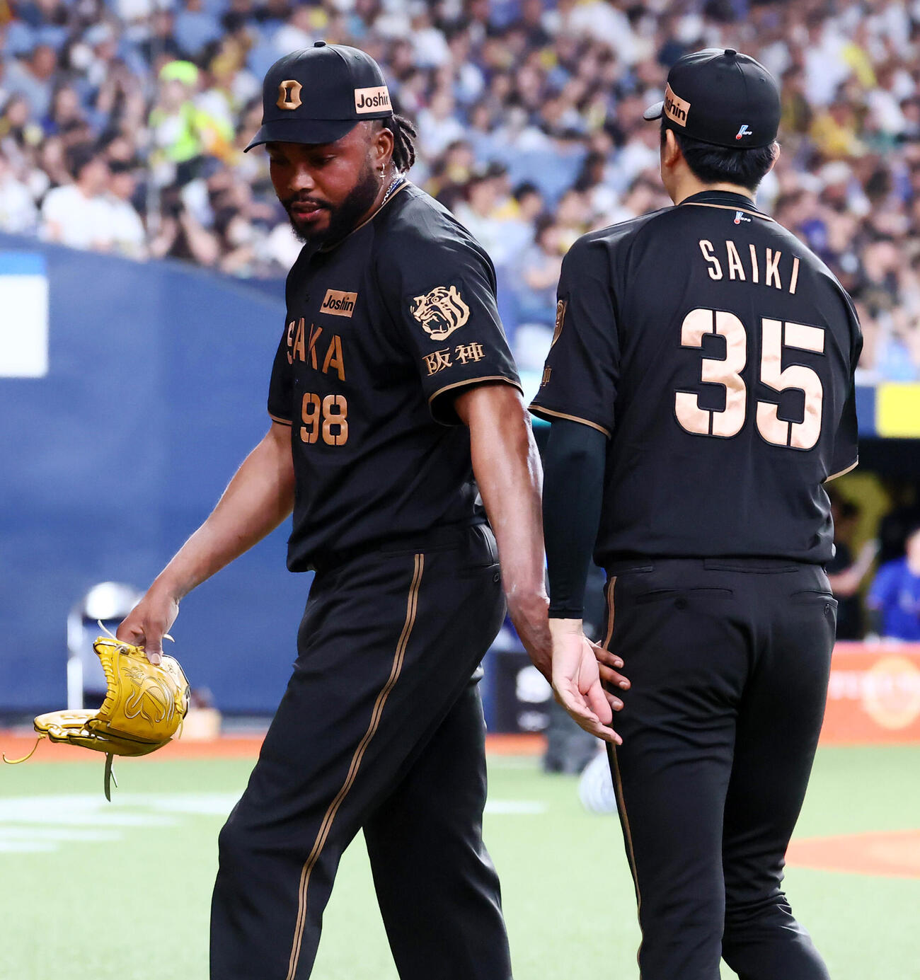 阪神対中日　9回表に登板し中日に逆転を許した阪神ラファエル・ドリスは才木浩人（左）の出迎えを受ける（撮影・加藤哉）