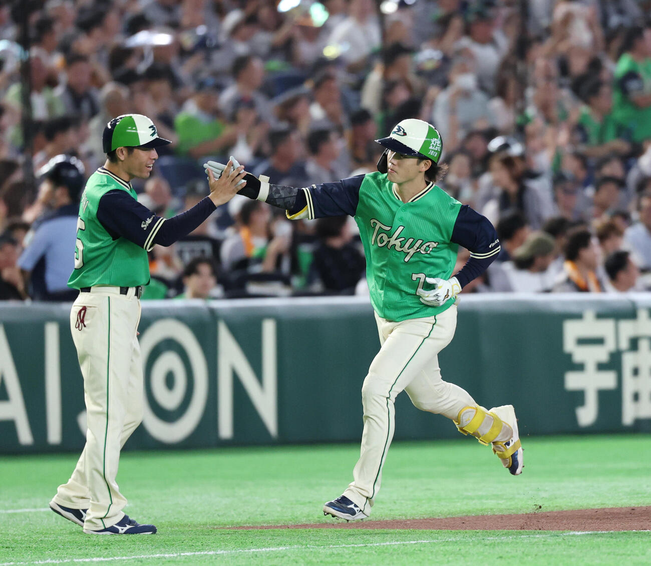巨人対ヤクルト　7回表ヤクルト2死、本塁打を放ち寺内崇幸コーチ（左)とタッチを交わす長岡秀樹（撮影・増田悦実）