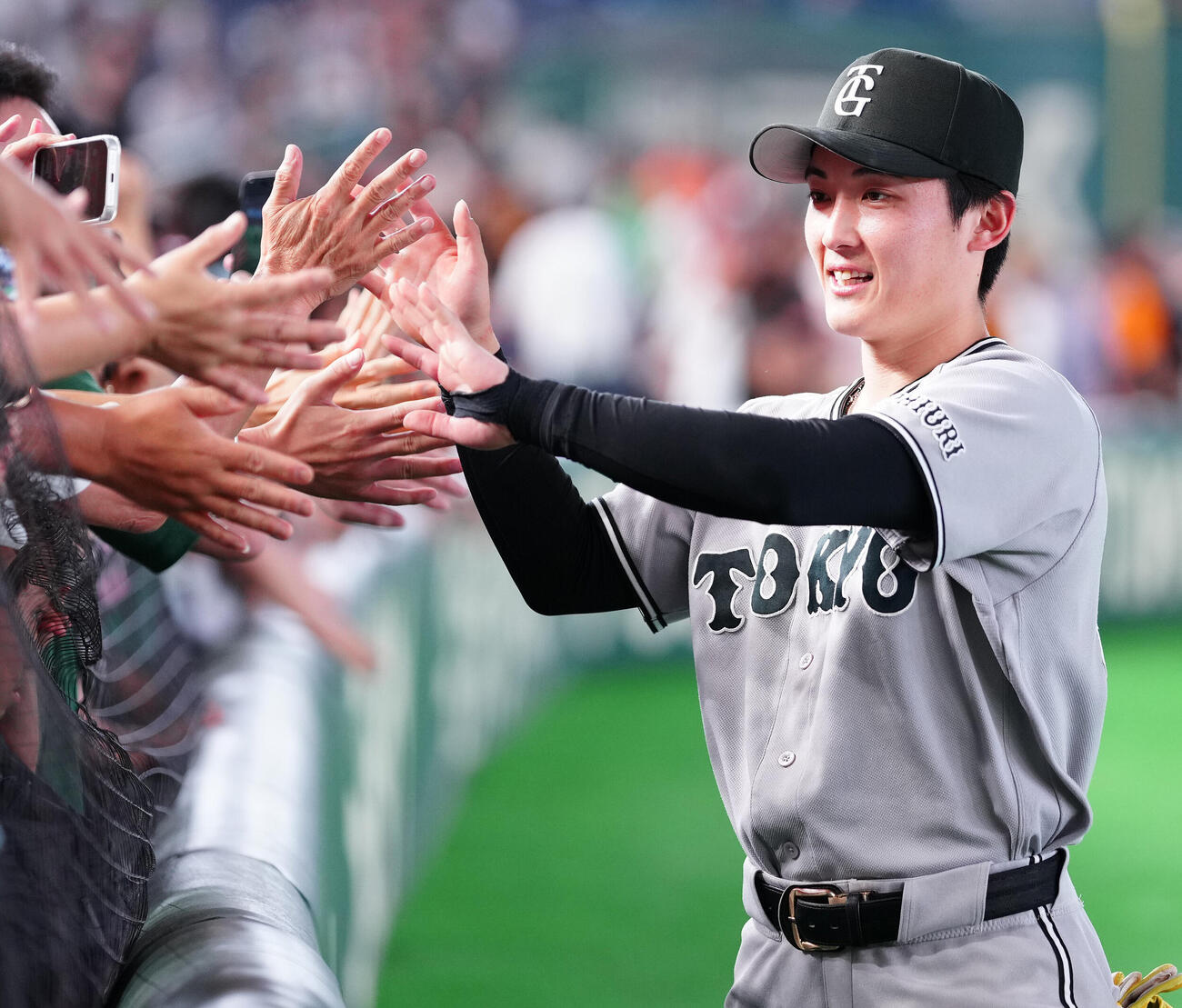 巨人対ヤクルト　ヤクルトに勝利し、ファンとハイタッチする巨人浦田俊輔（撮影・鈴木みどり）