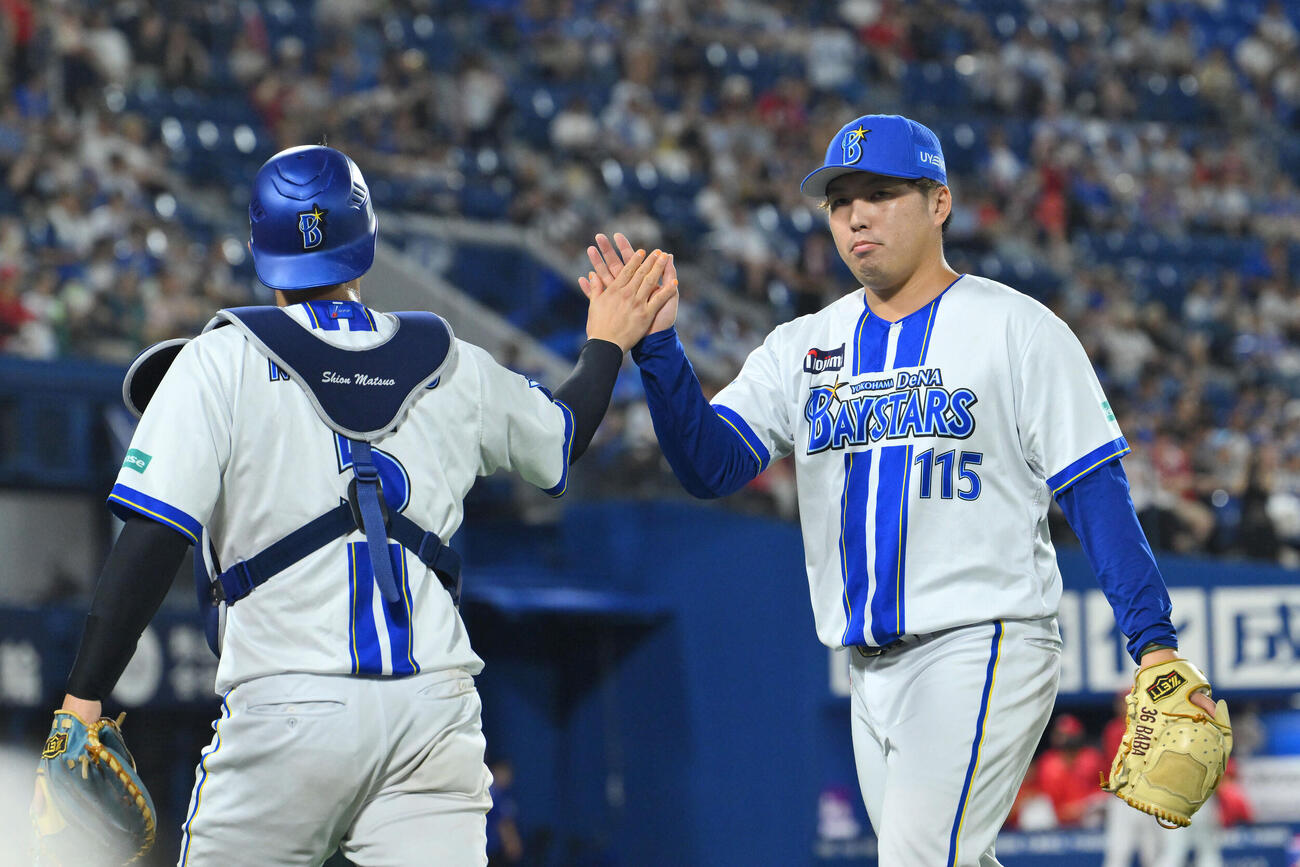DeNA対広島　11回表を投げ終えDeNA8番手の馬場皐輔（右）は松尾汐恩とタッチを交わす（撮影・滝沢徹郎）