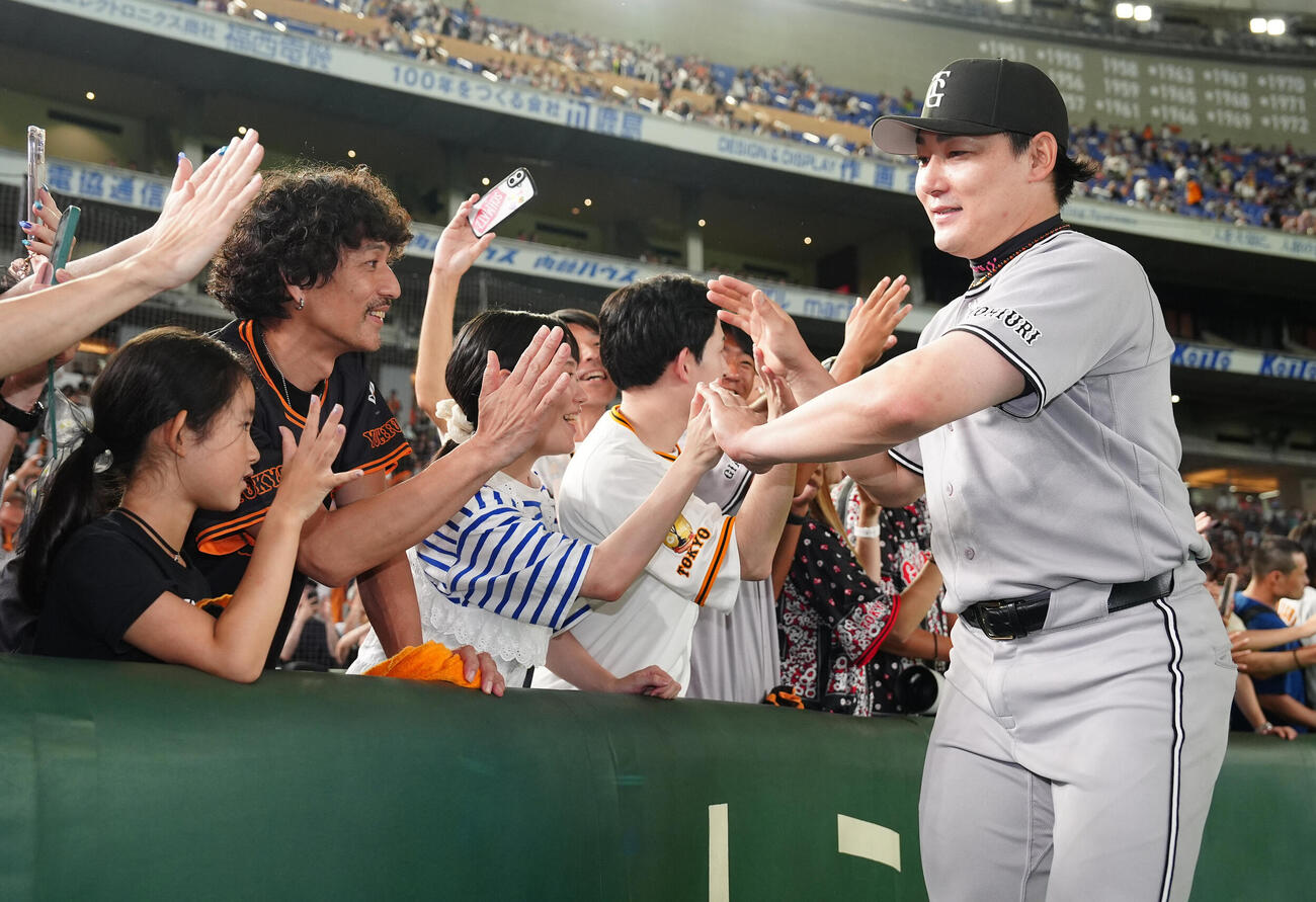 巨人対ヤクルト　ファンとハイタッチする巨人丸佳浩（撮影・鈴木みどり）
