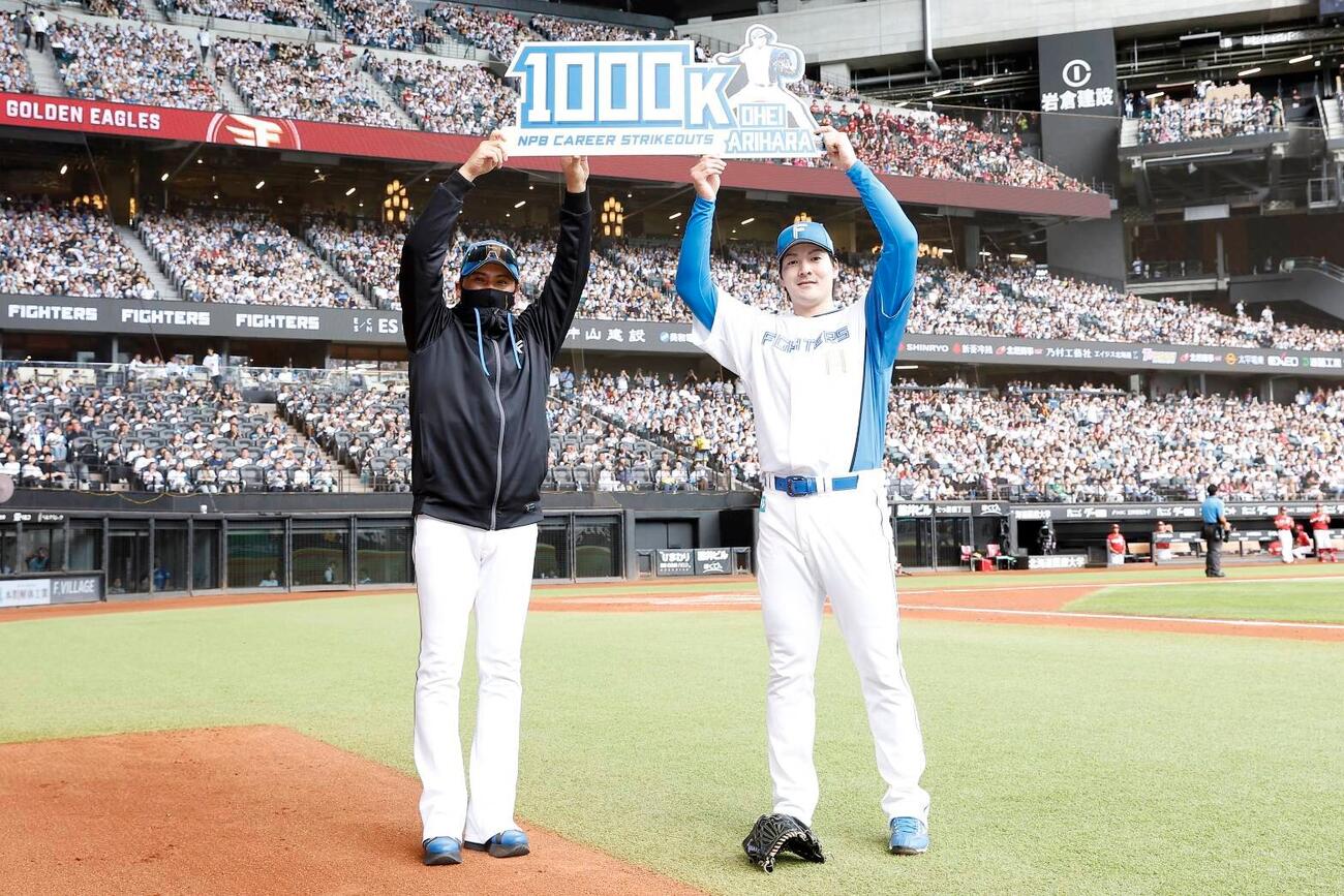 日本ハム対楽天　NPB通算1000奪三振を達成し新庄剛志監督（左）と記念ボードを掲げる有原航平（球団提供）