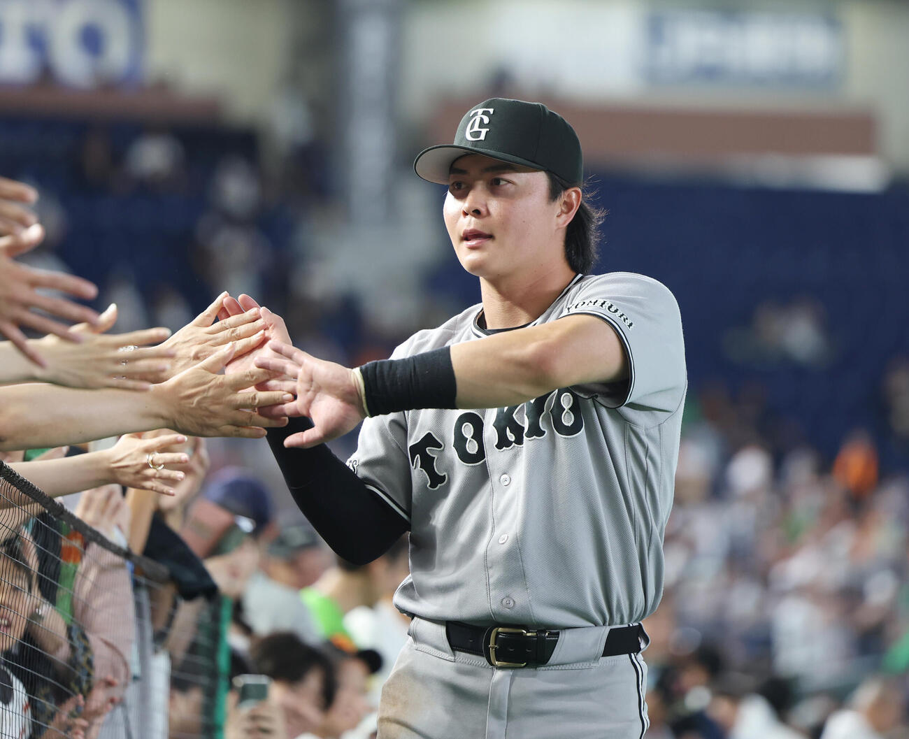 巨人対ヤクルト　勝利し観客とタッチをする巨人岡田悠希（撮影・増田悦実）