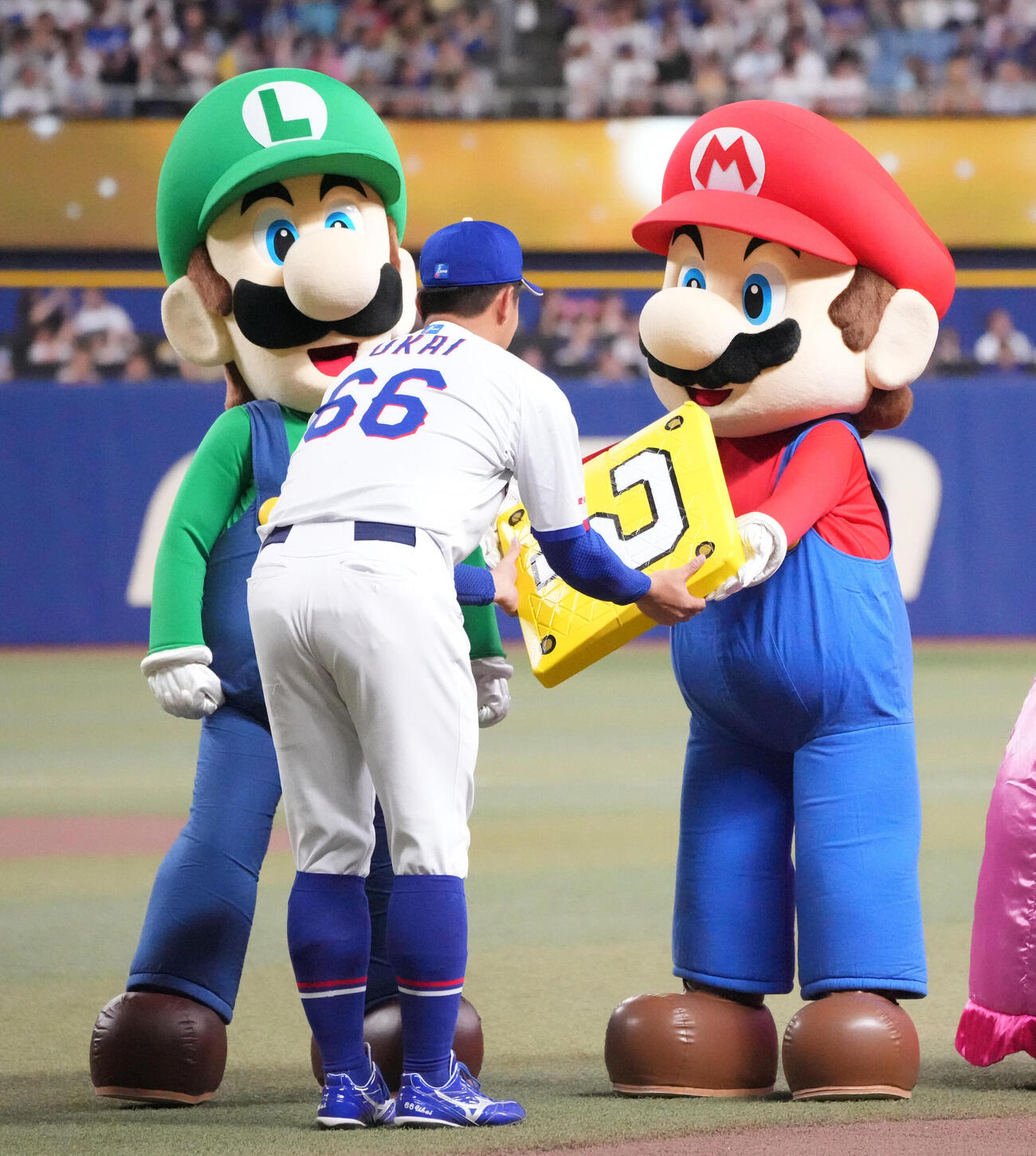 中日対DeNA　試合前、鵜飼航丞（中央）はマリオから記念デザインのベースを受け取る（撮影・森本幸一）