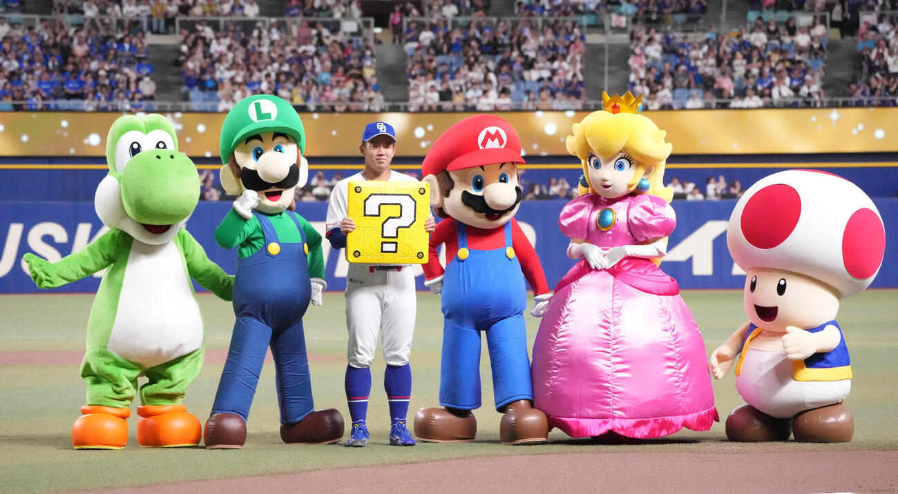 中日対DeNA　試合前、鵜飼航丞（左から2人目）はマリオから記念デザインのベースを受け取る（撮影・森本幸一）
