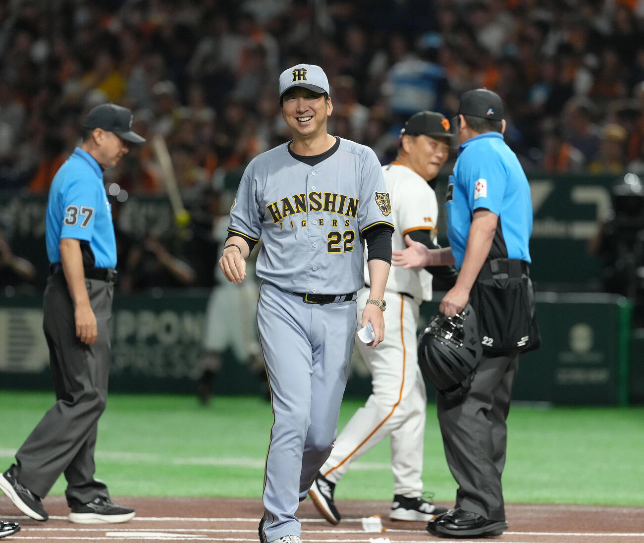 巨人対阪神　巨人橋上秀樹監督代行（後方）とのメンバー表交換を終え、笑顔でベンチに戻る阪神藤川球児監督（撮影・足立雅史）