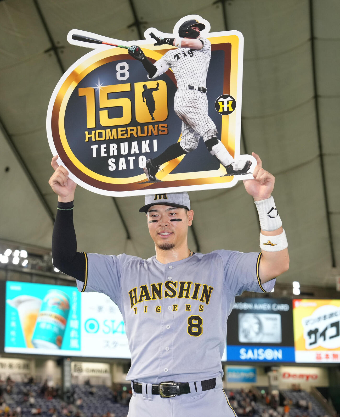 巨人対阪神　通算150号本塁打の記念ボードを掲げる阪神佐藤輝明（撮影・足立雅史）