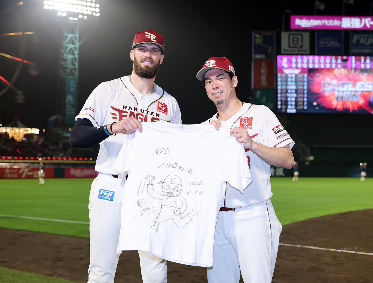 楽天対オリックス　マエケン画伯NPB通算100勝特製Tシャツを手に笑顔を見せる楽天マッカスカー（左）と前田健太（撮影・鈴木正人）